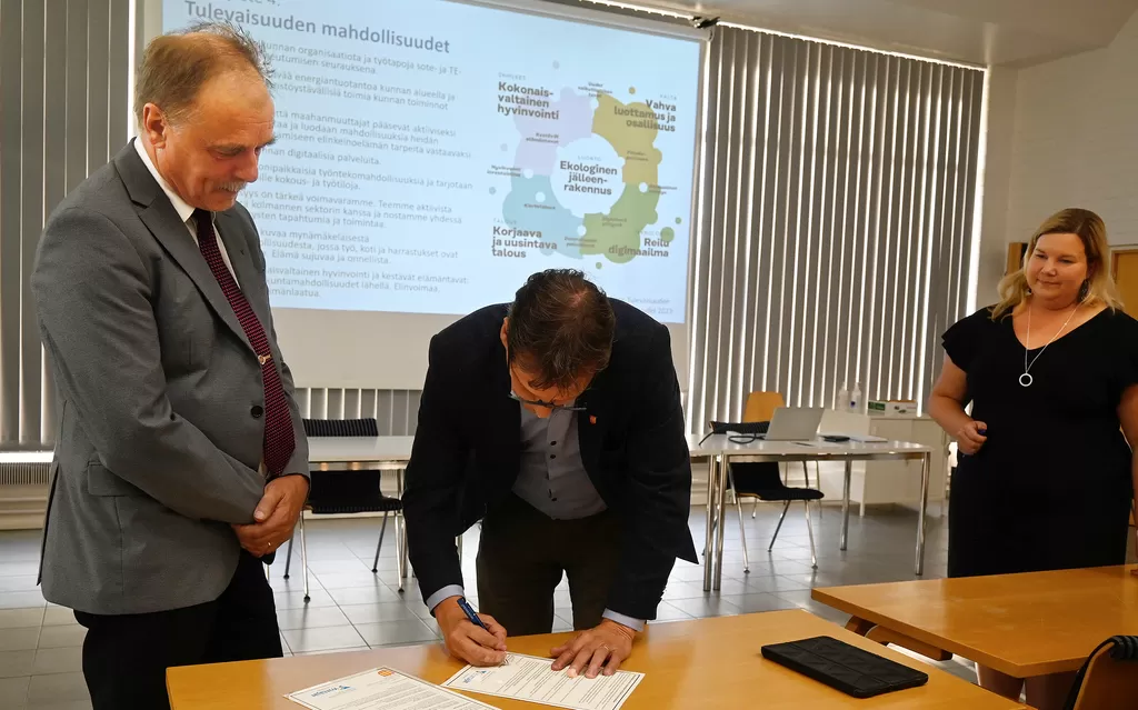 Esko Lehtonen ja Juha Vanhanen allekirjoittivat elinvoimalupauksen Yrittäjäillassa tiistaina. Taustalla Carita Maisila.