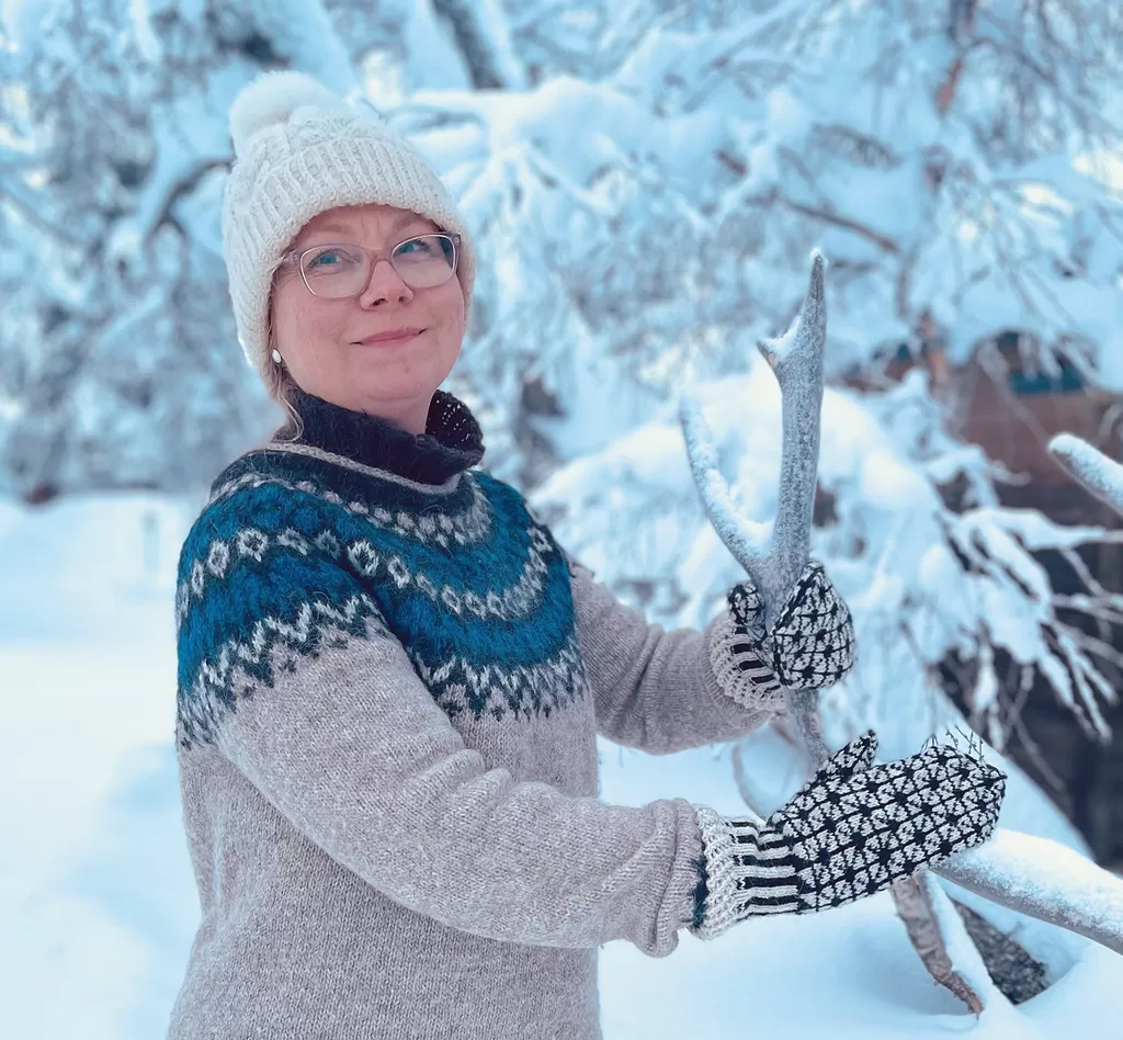 Marika Haloilalla käsissään vanhan mallin mukaan neulotut lapaset.