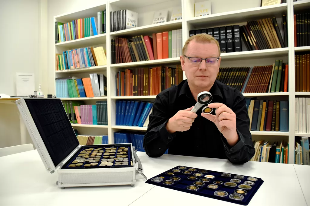 Tatu Untinen tarkastelee arvioitavaksi tuotuja vanhoja kultakolikoita. Vuonna 1878 painetun 20 markan kultakolikon arvo on tänä päivänä yli 500 euroa.